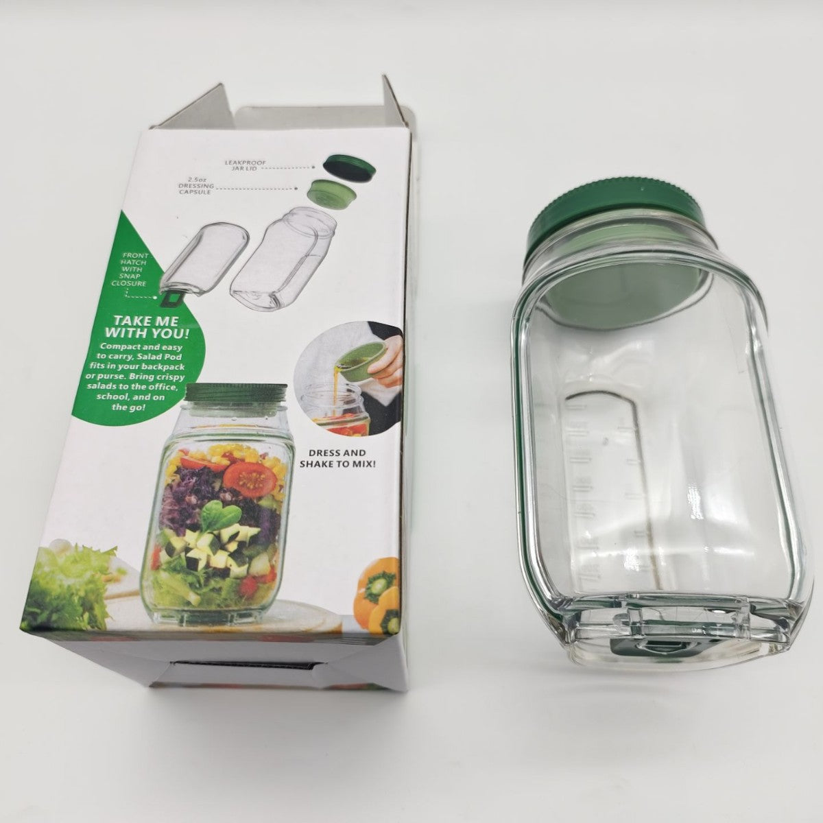 Glass jar with green lid and packaging on a white background